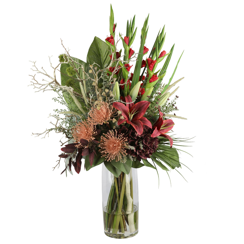 Red Gladiolus and Pincushion Protea Dramatic Artificial Arrangement with tall red gladioli, crimson oriental lilies, coral pincushion proteas, burgundy dahlias, and tropical foliage in a tall glass cylinder vase