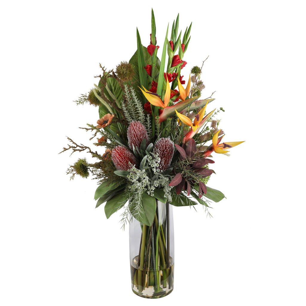 Bird of Paradise and Banksia Tropical Showpiece Artificial Arrangement with bird of paradise flowers, red gladioli, burgundy-pink banksia proteas, peach anemone, and wild mixed greenery in a tall glass cylinder vase