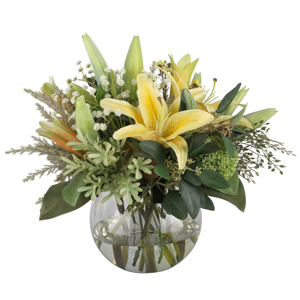 Golden Lily and Wax Flower Sunshine Artificial Arrangement with golden yellow asiatic lilies, white wax flowers, dusty miller, green sedum, and eucalyptus in a glass fishbowl vase
