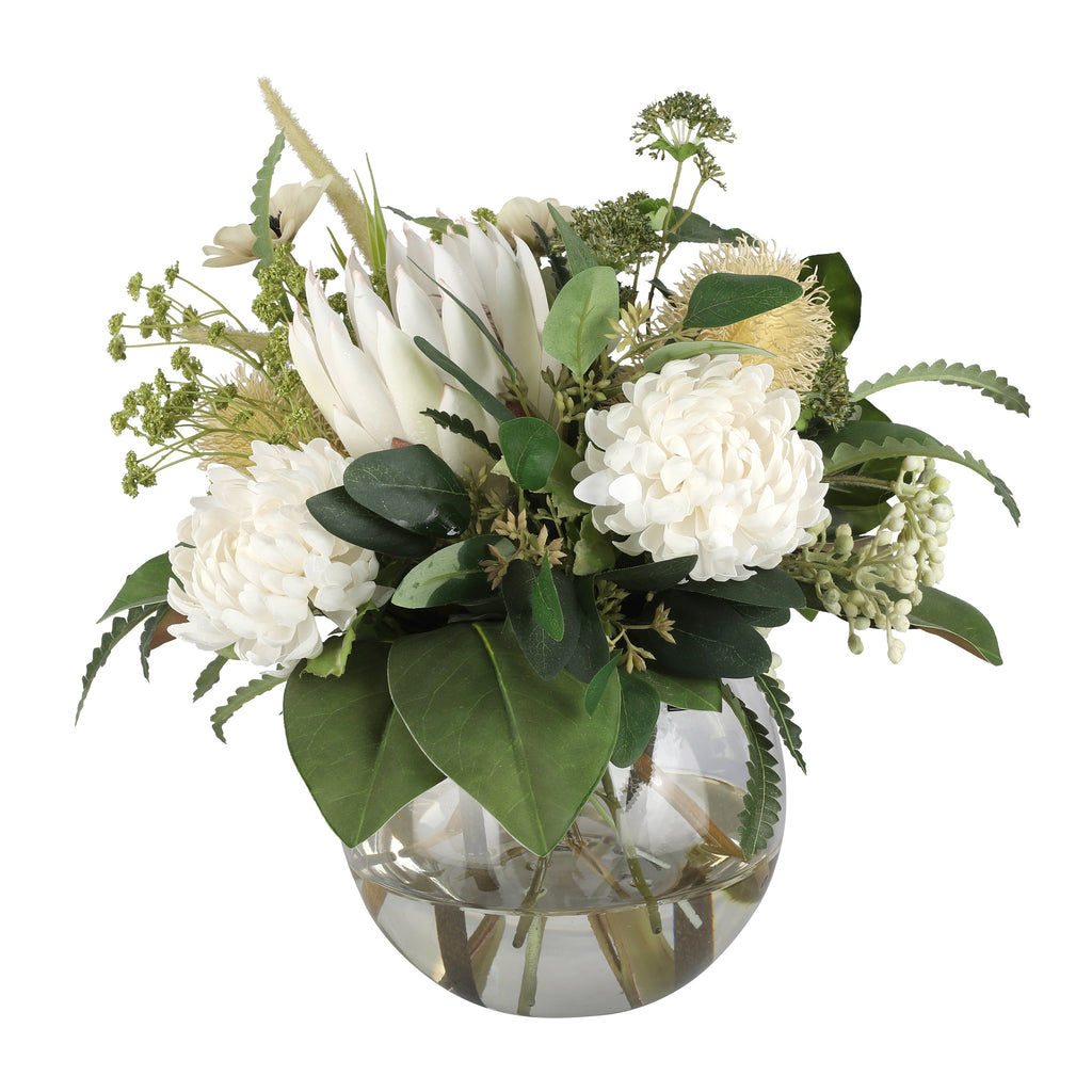 White Protea and Hydrangea Garden Elegance Artificial Arrangement with white king protea, white hydrangeas, golden banksia, white pampas grass, and mixed greenery in a glass fishbowl vase