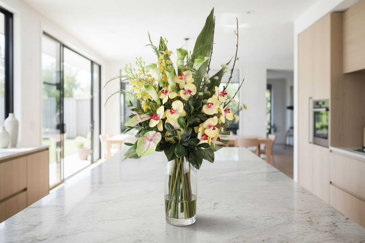 Large Cream Cymbidium Orchid and Calla Lily artificial arrangement preserved from the original product photo on a kitchen surface, grounded in a tall clear cylinder vase, 90 x 40 cm